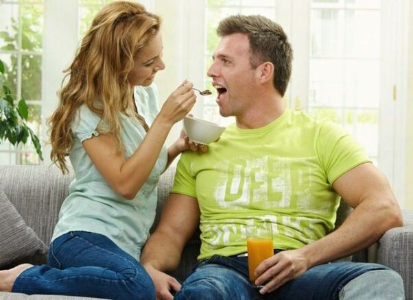 a woman feeds a man with products to increase the potency